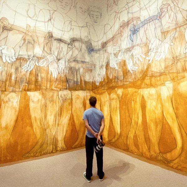 a man inside an art museum looking at the painted wall