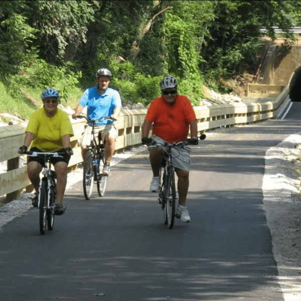 3 people riding on a bike path